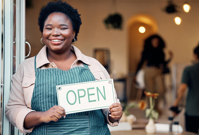 woman holding a open business sign